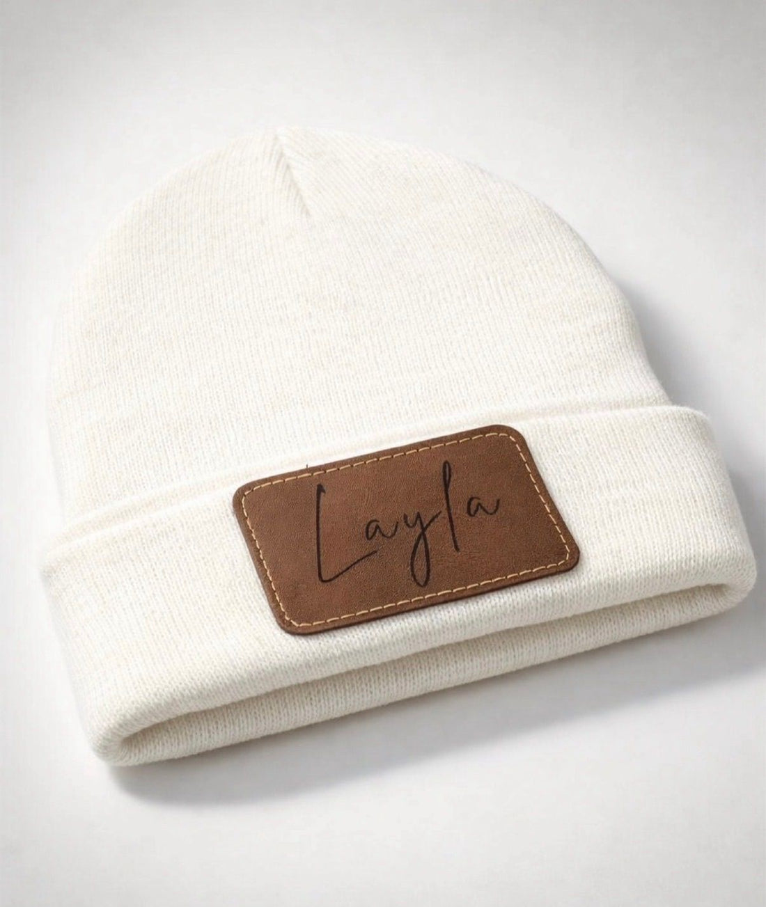 Cream knit beanie personalized with the name Layla on a faux leather patch