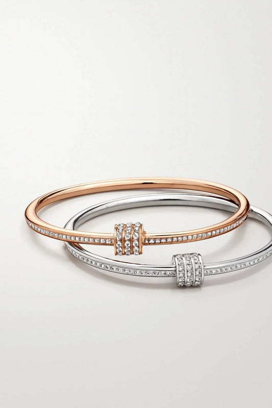 Two elegant diamond-studded bangle bracelets in rose gold and silver on white background