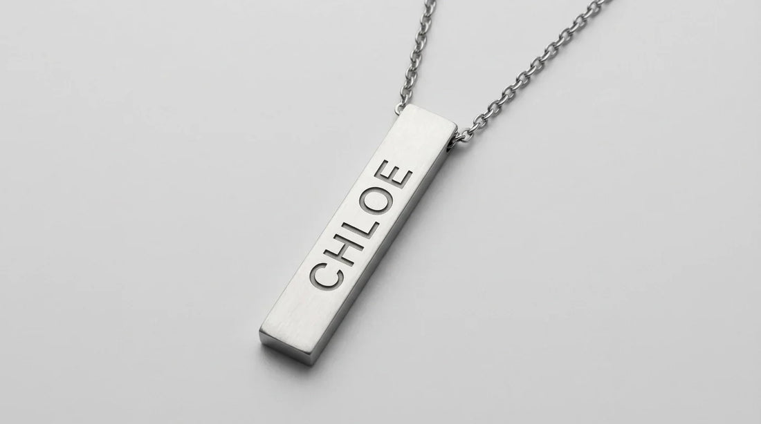 Silver bar pendant necklace with engraved name Chloe on fine chain against light background