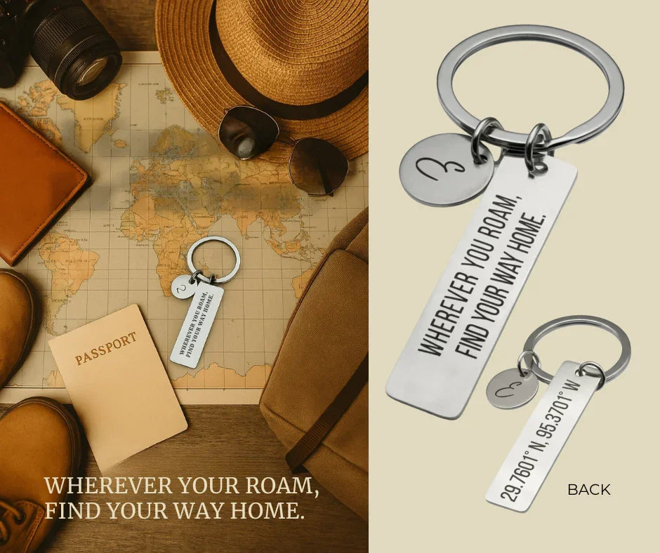 Silver keychain with engraved message 'Wherever you roam, find your way home' placed on world map with passport, hat, sunglasses, boots