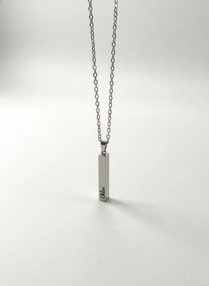 Silver chain necklace with a vertical rectangular pendant engraved with the name Chloe