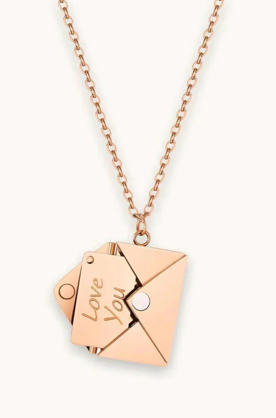 Rose gold chain necklace with an envelope pendant and a card engraved with Love You